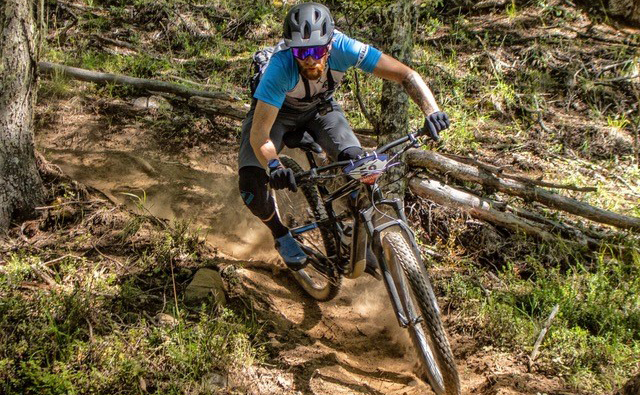 A professional mountain bike instructor rides a downhill course.