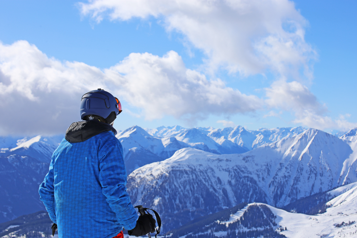 A skier looks at the mountain peaks.