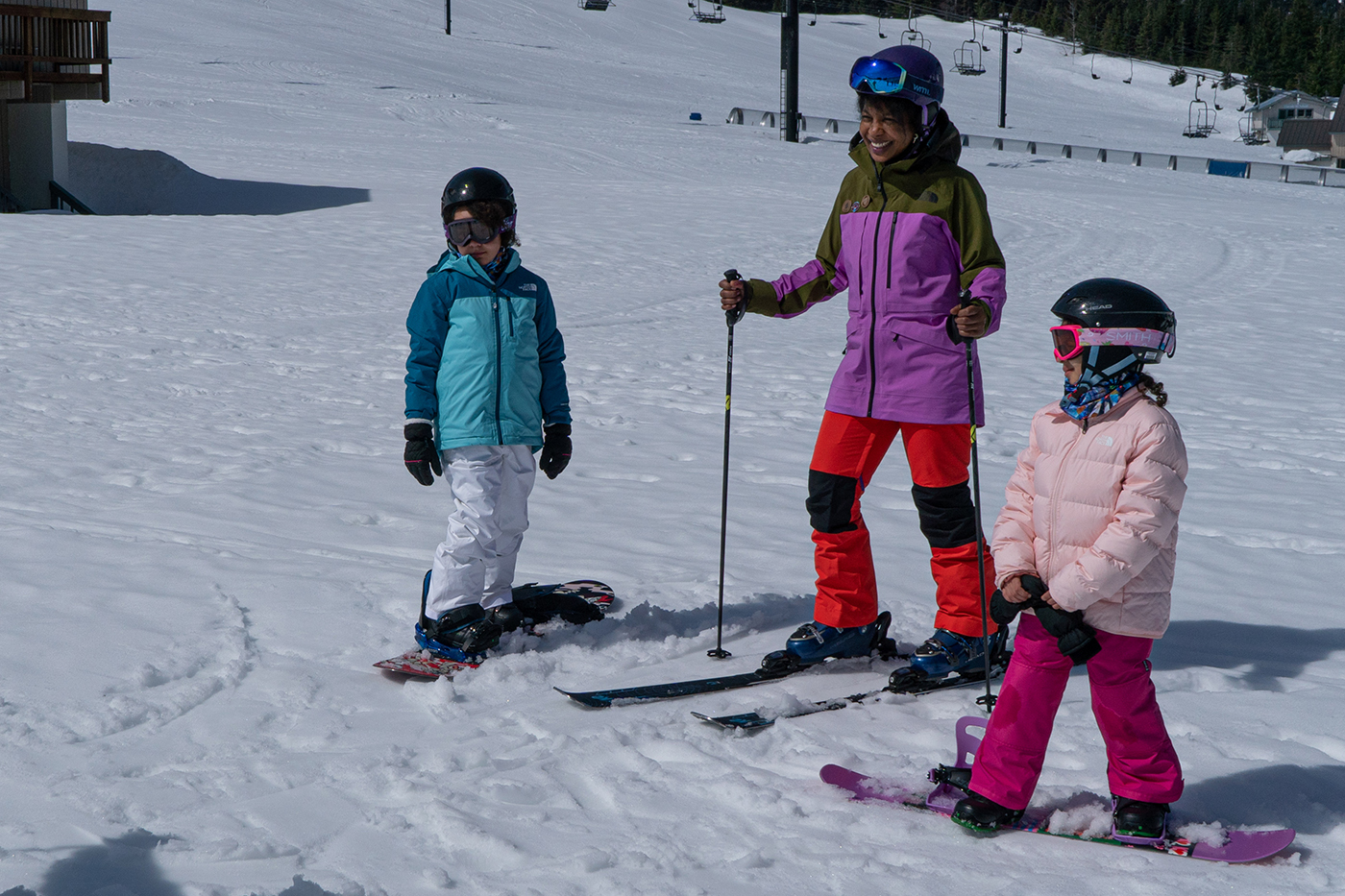 A family skis and snowboard